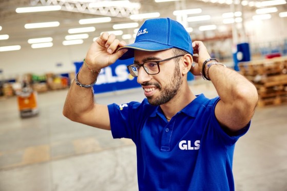 delivery man putting a GLS hat on his head