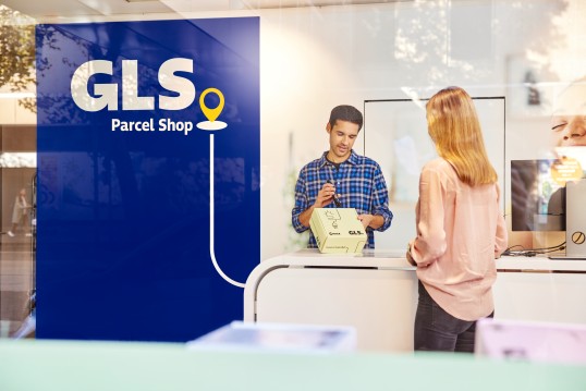 Woman picking up a parcel from a GLS Parcel Shop